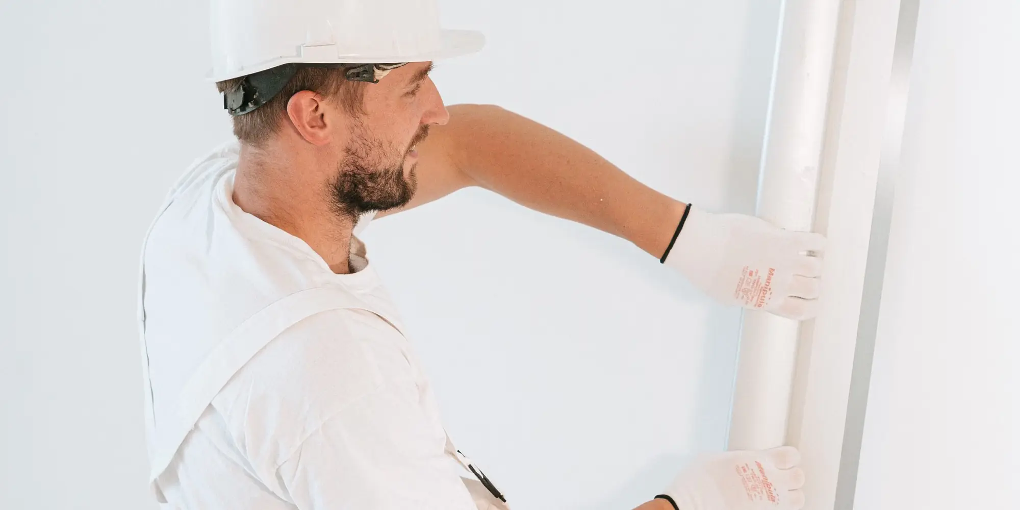 Drylining contractor fixing plasterboard to a metal frame