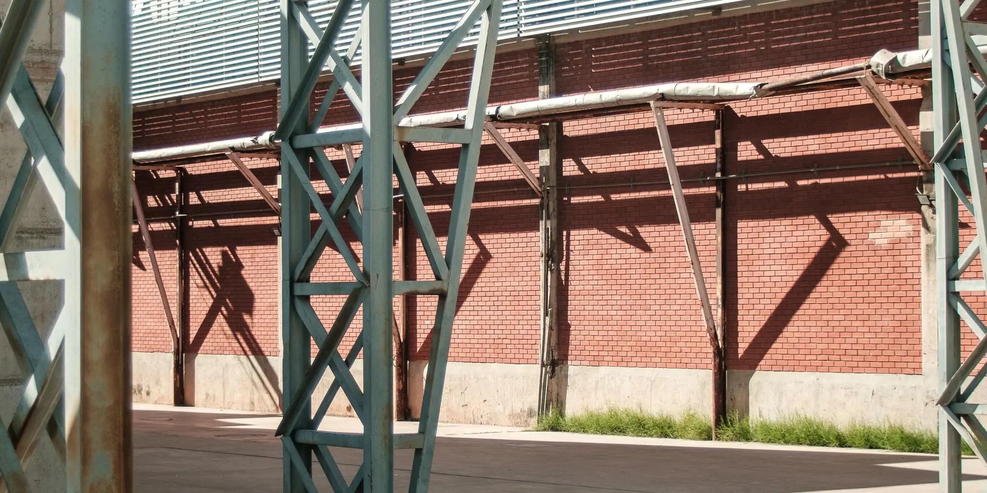 Structural steel framework rising in front of a brick building