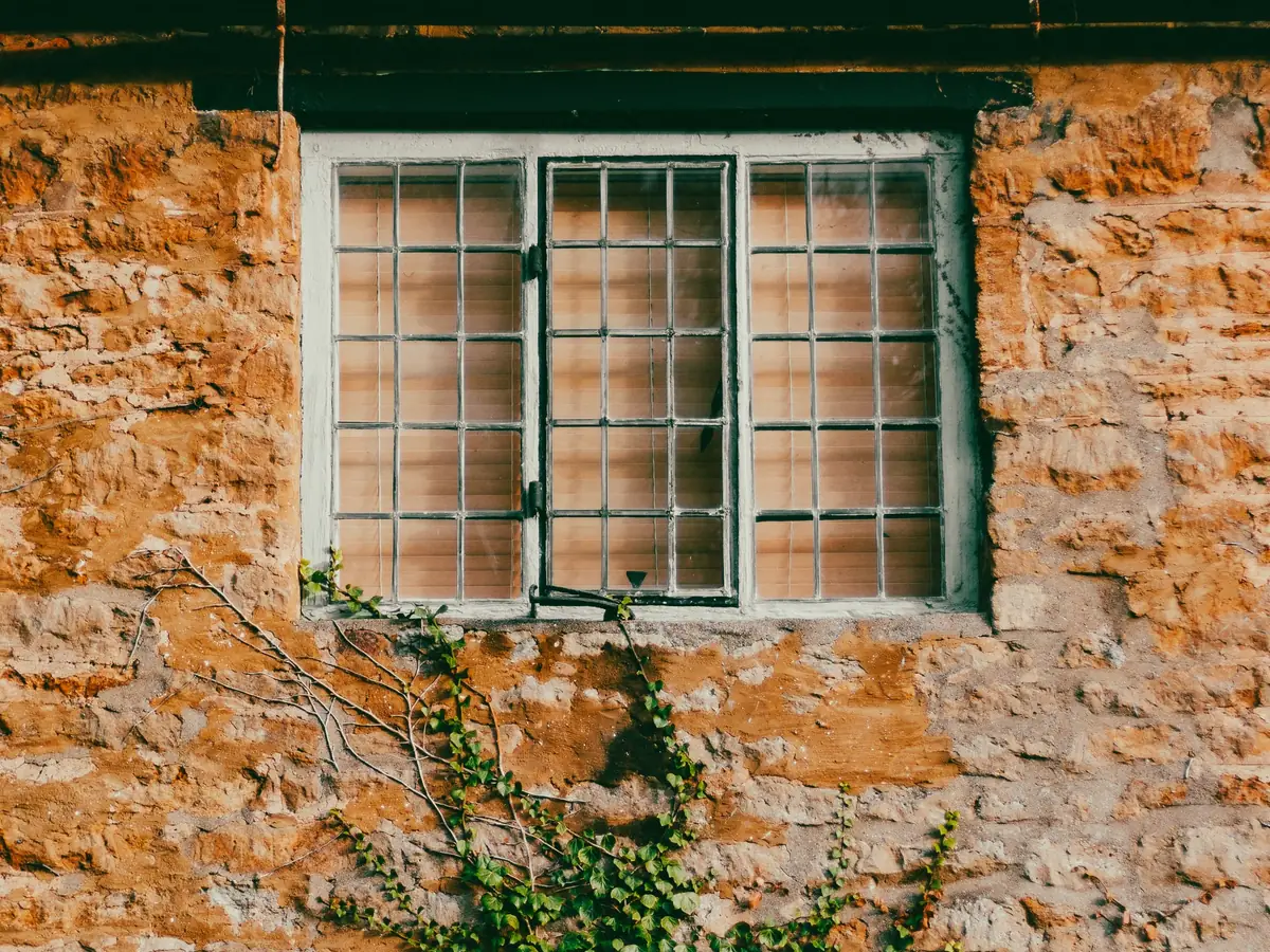 Old stone wall with a small window